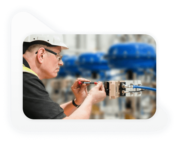 Homem branco e de óculos inspecionando máquina industrial